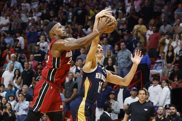 Jimmy Butler (i) de los Miami Heat disputa hoy el balón con Dyson Daniels de los New Orleans Pelicans, durante un partido de la NBA en el AmericanAirlines Arena de Miami, Florida EFE/ Rhona Wise
