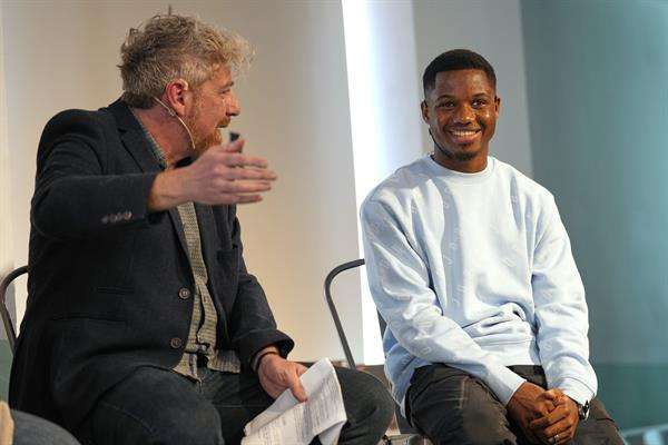 El jugador del FC Barcelona Ansu Fati, acompañado del periodista Santi Giménez, durante el acto en el que se presentó la recaudación total por la venta de la 17 edición del libro de relatos solidarios. EFE/Alejandro Garcia