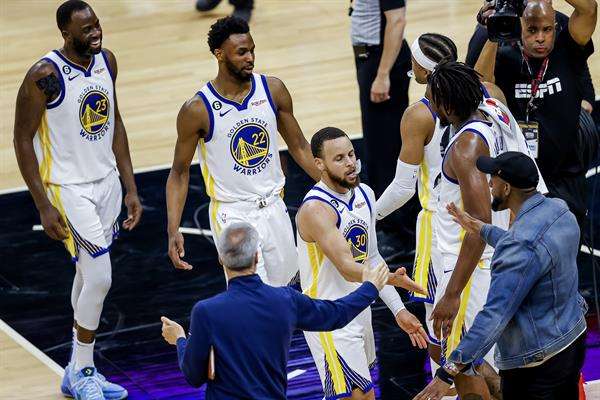 El escolta de los Warriors, Stephen Curry (d.), el alero de los Warriors, Andrew Wiggins (c), de Canadá, y el alero Draymond Green (i), son recibidos en el banquillo en los minutos finales de la segunda mitad del juego 7 de la primera ronda de playoffs de la Conferencia Oeste de la NBA. serie entre los Golden State Warriors y los Sacramento Kings en el Golden 1 Center en Sacramento, California, EE. UU., el 30 de abril de 2023. (Baloncesto, Estados Unidos) EFE/EPA/JOHN G. MABANGLO