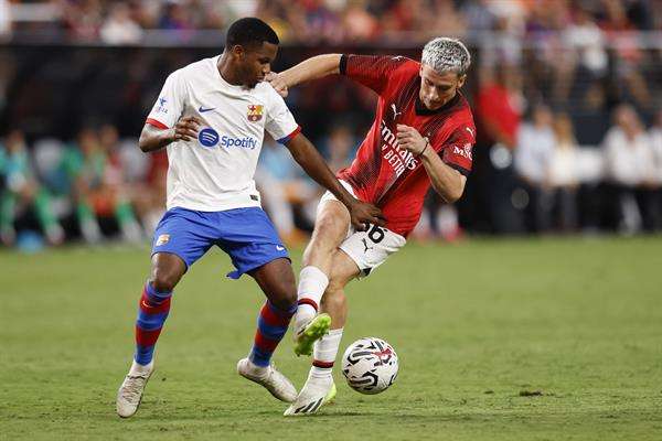 El delantero del Barcelona Ansu Fati (i) pugna con el jugador del Milan Alexis Jesse Saelemaekers (d) en el amistoso disputado por ambos equipos en Las Vegas. EFE/EPA/CAROLINE BREHMAN