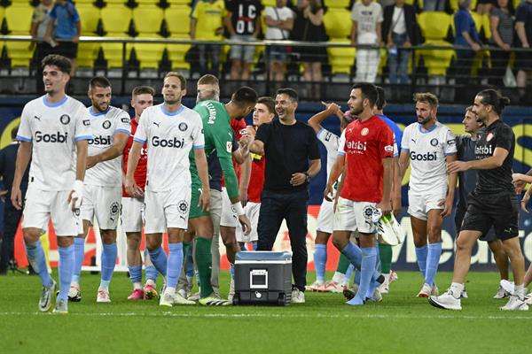 Los jugadores y el técnico del Girona, Míchel Sánchez, celebran su victoria en el campo del Villarreal que les dio el liderato de LaLiga por primera vez en su historia. EFE / Andreu Esteban.