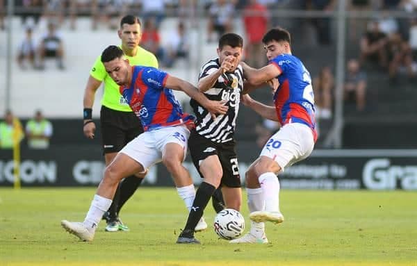 Hernesto Caballero (c), de Libertad, fue registrado este lunes, 6 de noviembre, al disputar un balón con Fabrizio José Peralta Ramírez (i) y Wilder Viera (d), de Cerro Porteño, durante un partido del Torneo Clausura del fútbol en Paraguay, en el estadio Tigo La Huerta, en Asunción (Paraguay). EFE/Daniel Piris