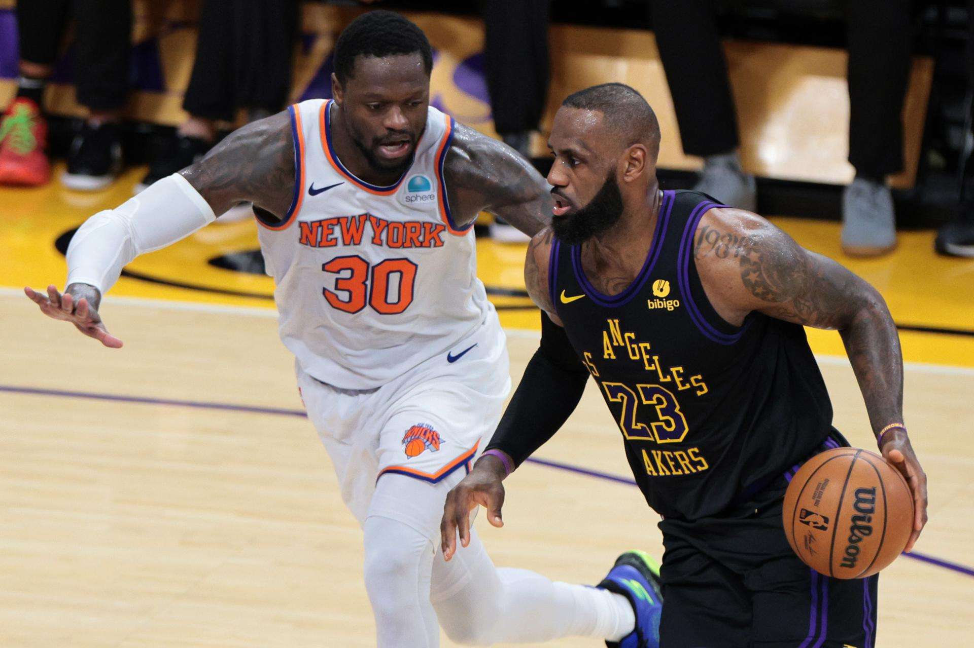 El juagador de los Angeles Lakers LeBron James (d) regatea el balón pasando por Julius Randle de los New York Knicks durante la primera mitad del partido de baloncesto de la NBA.EFE/EPA/ALLISON CENA