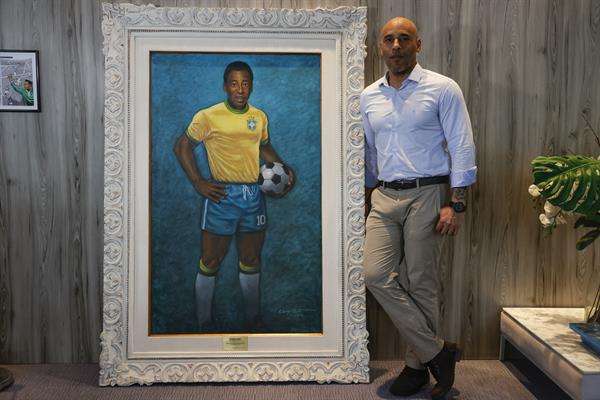 Edinho, hijo de Pelé, posa junto a un retrato de su padre durante una entrevista con EFE el 19 de diciembre de 2023, en el Museo Pelé, en la ciudad de Santos (Brasil). EFE/Sebastião Moreira
