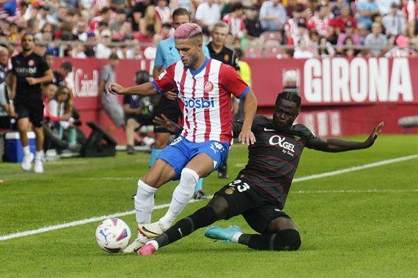 El defensa brasileño del Girona Yan Couto (i) disputa una posesión ante Amath Ndiaye (d), delantero senegalés del Mallorca durante el encuentro que los enfrentó en la jornada 6 de LaLiga. EFE/ David Borrat