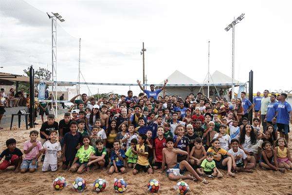 Fotografía cedida por la oficina de prensa de Endrick que muestra al deportista mientras posa con participantes de un torneo de 'futvolei'. EFE/ André Pera