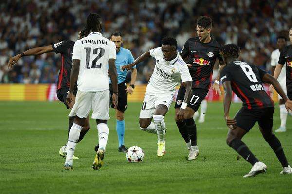 El delantero del Real Madrid Vinicius Jr (c) rodeado por jugadores del Leipzig, durante el partido de la fase de grupos que disputaron la pasada campaña en el Santiago Bernabéu. EFE/JUANJO MARTIN