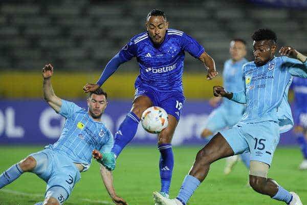Gustavo Vallecilla (d) y Fausto Grillo (i), defensas de la Universidad Católica de Ecuador, fueron registrados este jueves, 4 de abril, al disputar un balón con Rafael Elías da Silva (c), del Cruzeiro de Brasil, durante un partido del grupo B de la Copa Sudamericana, en el estadio Olímpico Atahualpa, en Quito (Ecuador). EFE/José Jácome