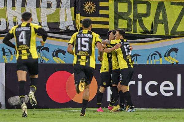 Jugadores del club uruguayo de fútbol Peñarol fueron registrados el pasado 10 de abril al celebrar un gol de Maximiliano Silvera en un partido de la Copa Libertadores, en el estadio Campeón del Siglo de Montevideo (Uruguay). Los aurinegros se impusieron este domingo, 14 de abril, 2-0 a Danbudio en partido de la fecha 8 del torneo local. EFE/Gastón Britos