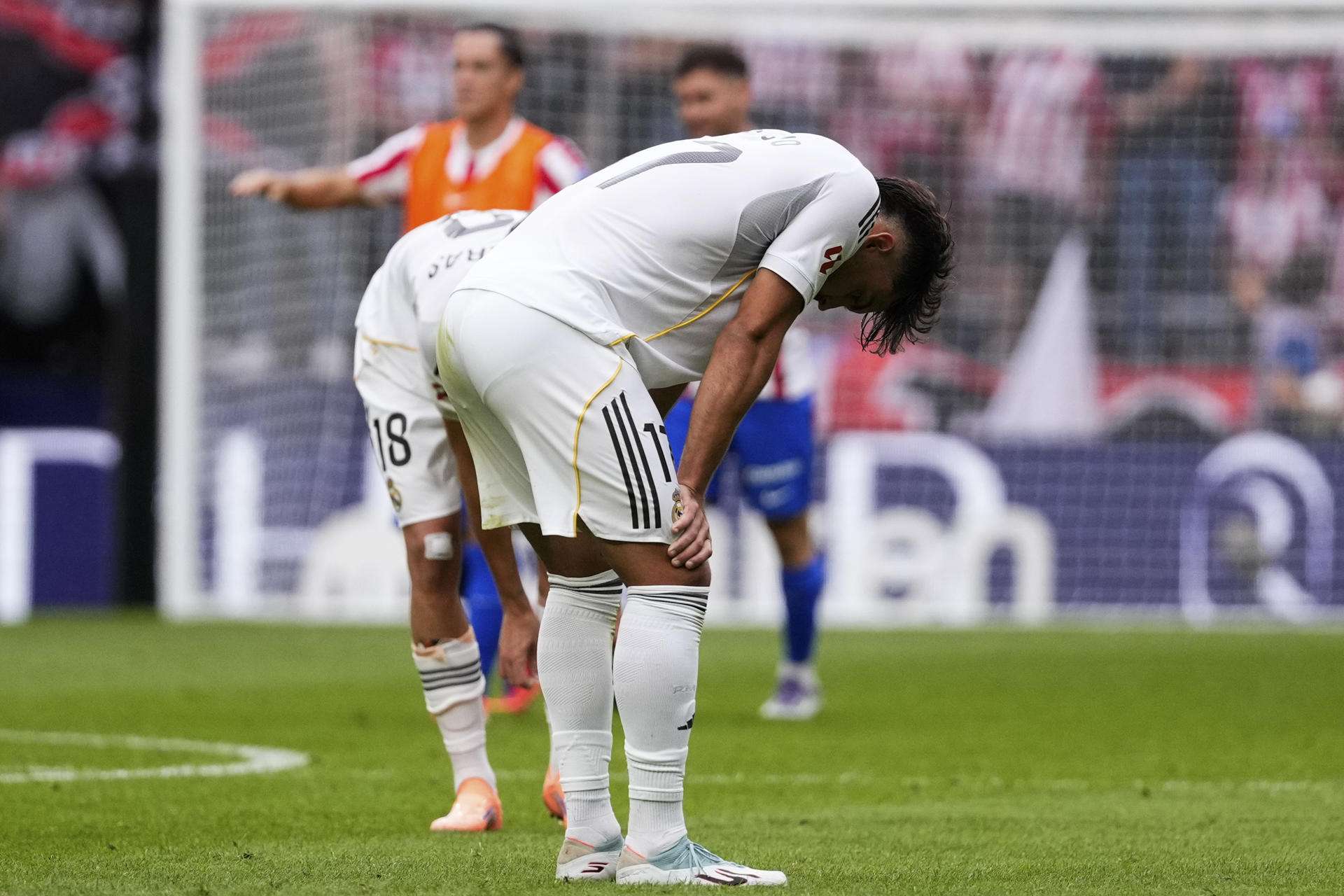 Los jugadores del Real Madrid Raúl Asencio y Álvaro Carreras (detrás), al final del partido de LaLiga entre el Real Madrid y el Atlético de Madrid que se disputó en el estadio Riyadh Air Metropolitano este sábado. EFE/Borja Sánchez-Trillo