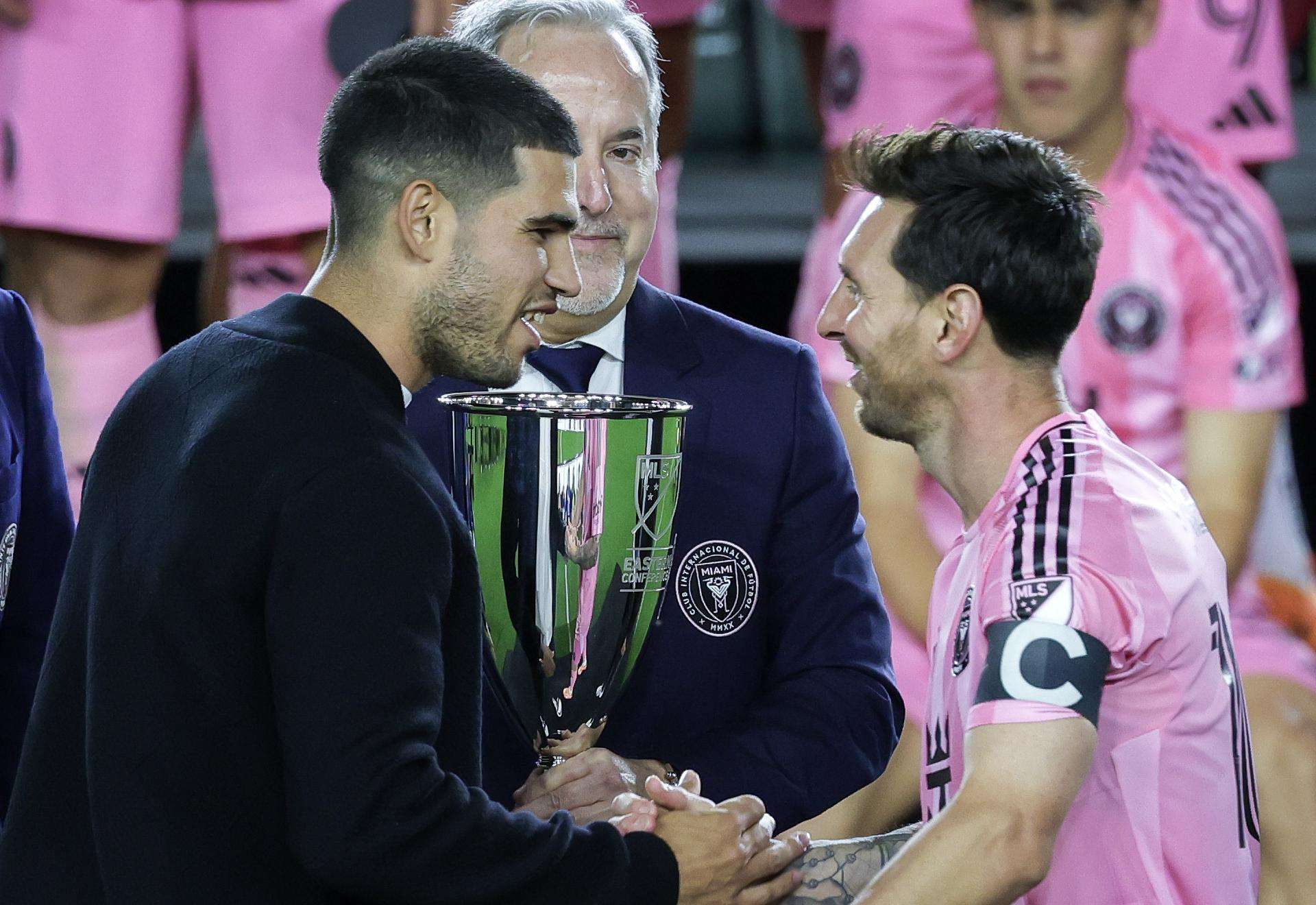 El tenista español Carlos Alcaraz (i) saluda este sábado al futbolista argentino Lionel Messi antes de entregar al capitán del Inter Miami la copa de campeón de la Conferencia Este de la MLS conquistada por el equipo violeta tras golear por 5-1 al New York Cityen el Chase Stadium de Fort Lauderdale (Florida). EFE/EPA/Cristobal Herrera Ulashkevich