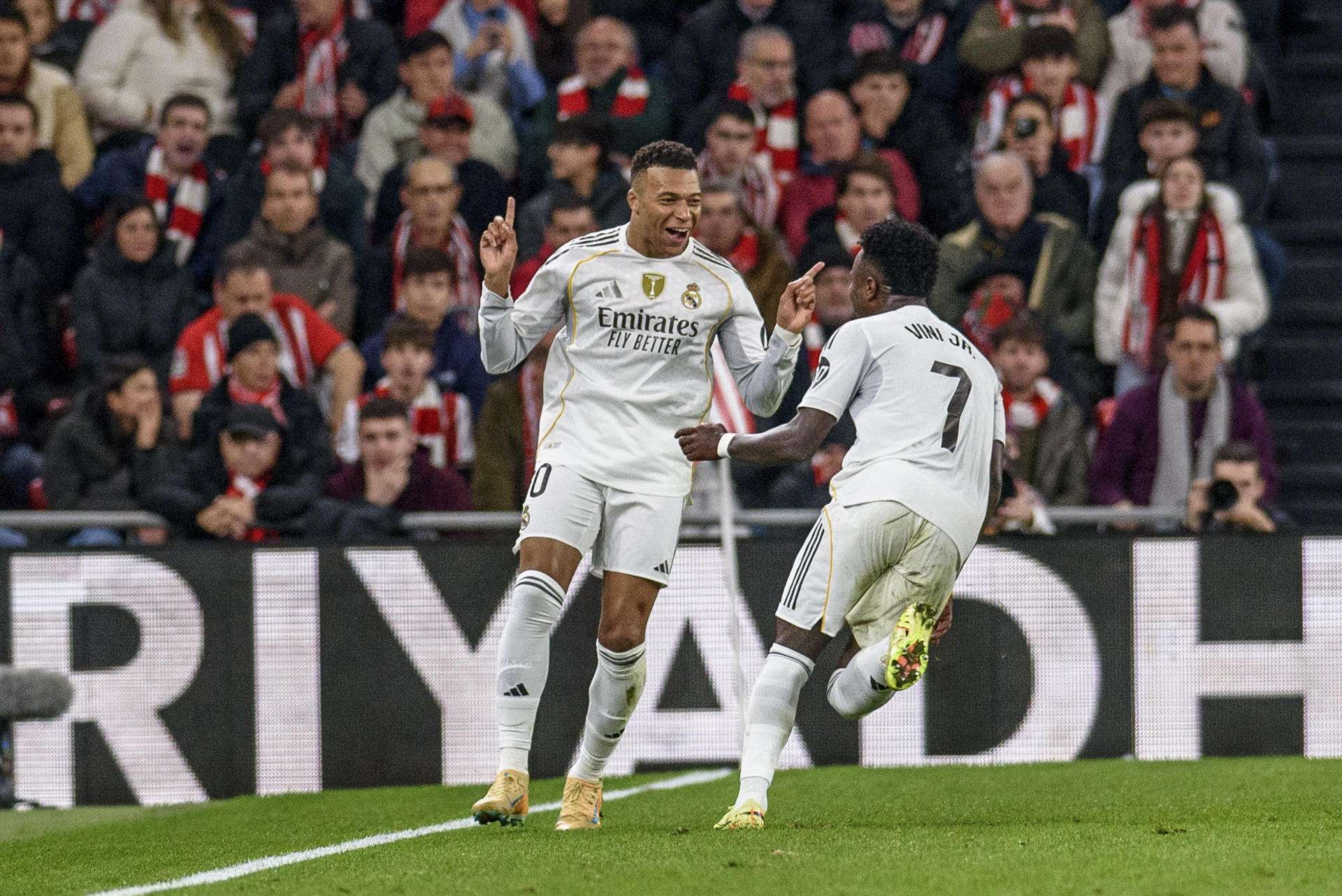 El delantero francés del Real Madrid Kylian Mbappé (izda) celebra el 0-3 conseguido durante el partido de la jornada 19 de LaLiga EA Sports entre el Athletic Club y el Real Madrid, disputado este miércoles en el estadio de San Mamés en Bilbao. EFE/Javier Zorrilla