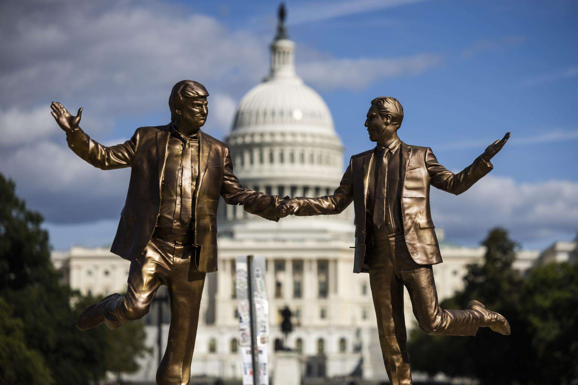Foto de archivo de una estatua instalada brevemente el 23 de septiembre pasado frente al Capitolio estadounidense en Washington, y que muestra al presidente estadounidense, Donald Trump (i), de la mano del abusador sexual de menores Jeffrey Epstein. EFE/EPA/JIM LO SCALZO