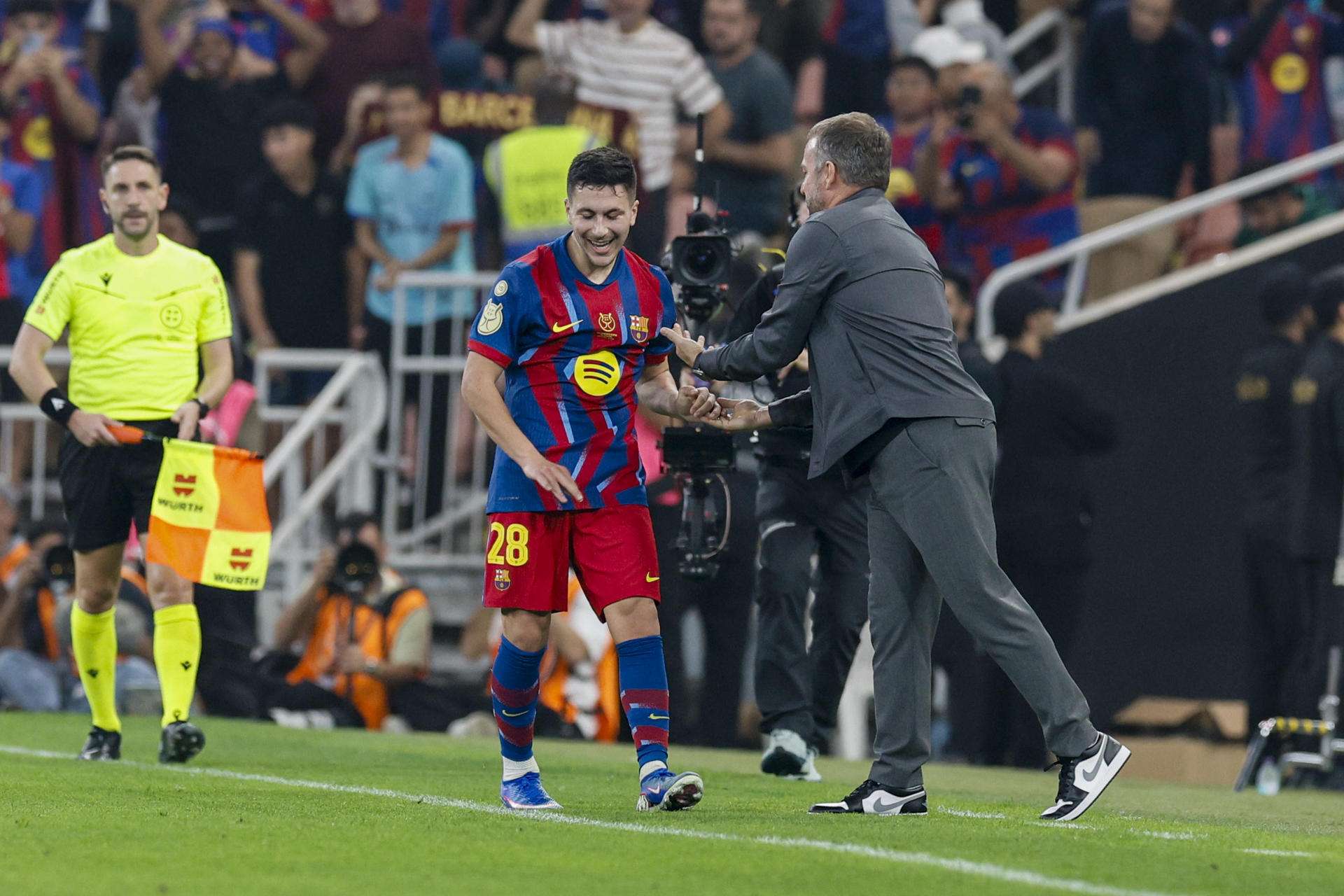 El centrocampista del Barcelona Roony Bardghji (c) celebra con Hansi Flick (d) tras marcar ante el tercer gol ante el Athletic, durante el partido de semifinales de la Supercopa de España que FC Barcelona y Athletic Club disputaron este miércoles en Yeda (Arabia Saudí). EFE/Kai Forsterling