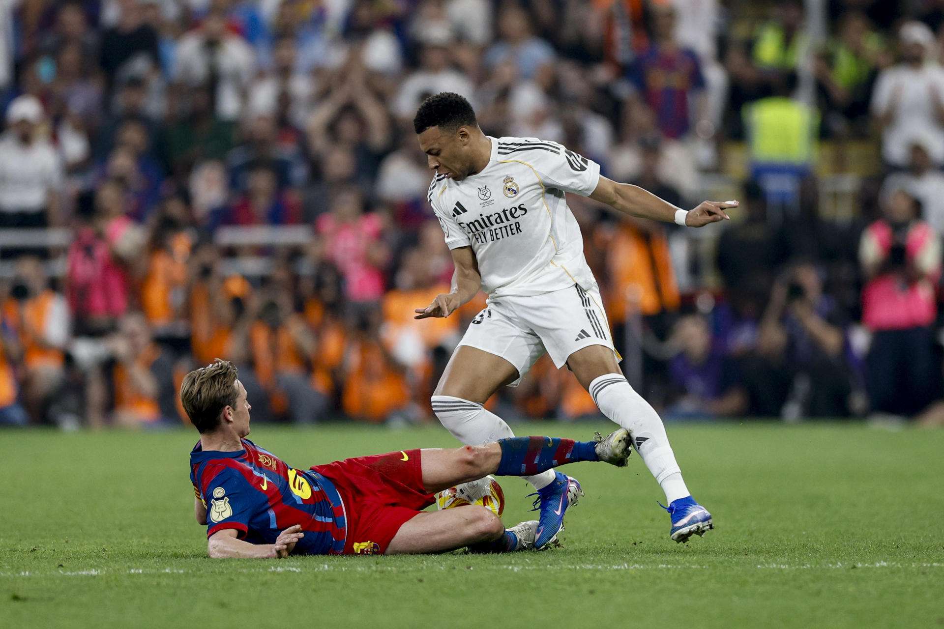 El centrocampista del FC Barcelona Frenkie de Jong (i) comete falta ante el delantero del Real Madrid Kylian Mbappé (d) durante la final de la Supercopa de España entre el FC Barcelona y el Real Madrid, este domingo en el estadio Ciudad Deportiva del Rey Abdalá de Yeda (Arabia Saudí). EFE/ Kai Försterling