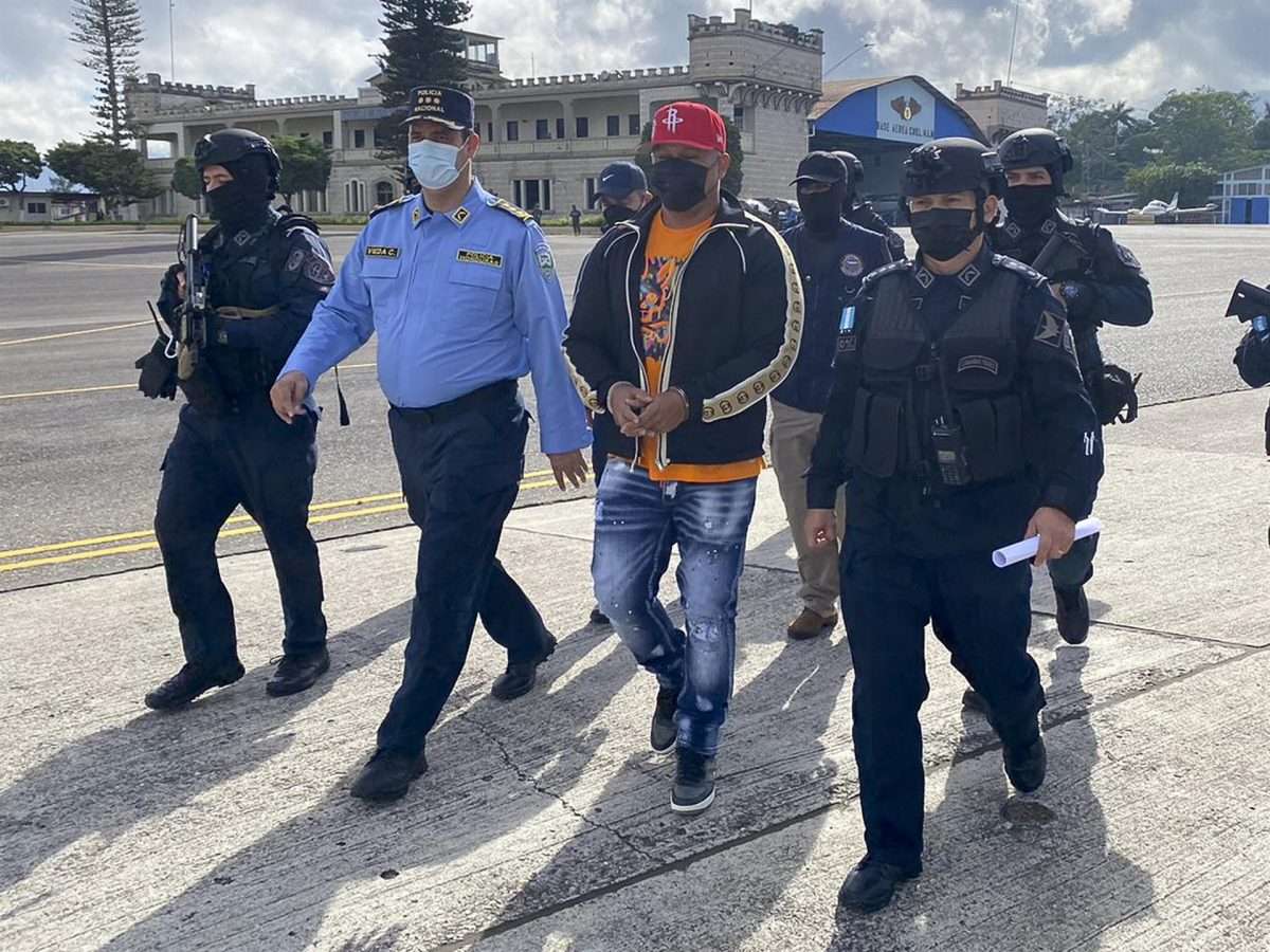 al presunto narcotraficante hondureño José Luis Oliva (c), alias "El señor de los cielos", mientras es trasladado a un avión de la DEA para ser extraditado a los Estados Unidos, en la base aérea Hernán Acosta Mejía, en Tegucigalpa (Honduras). (Foto La Red: EFE)