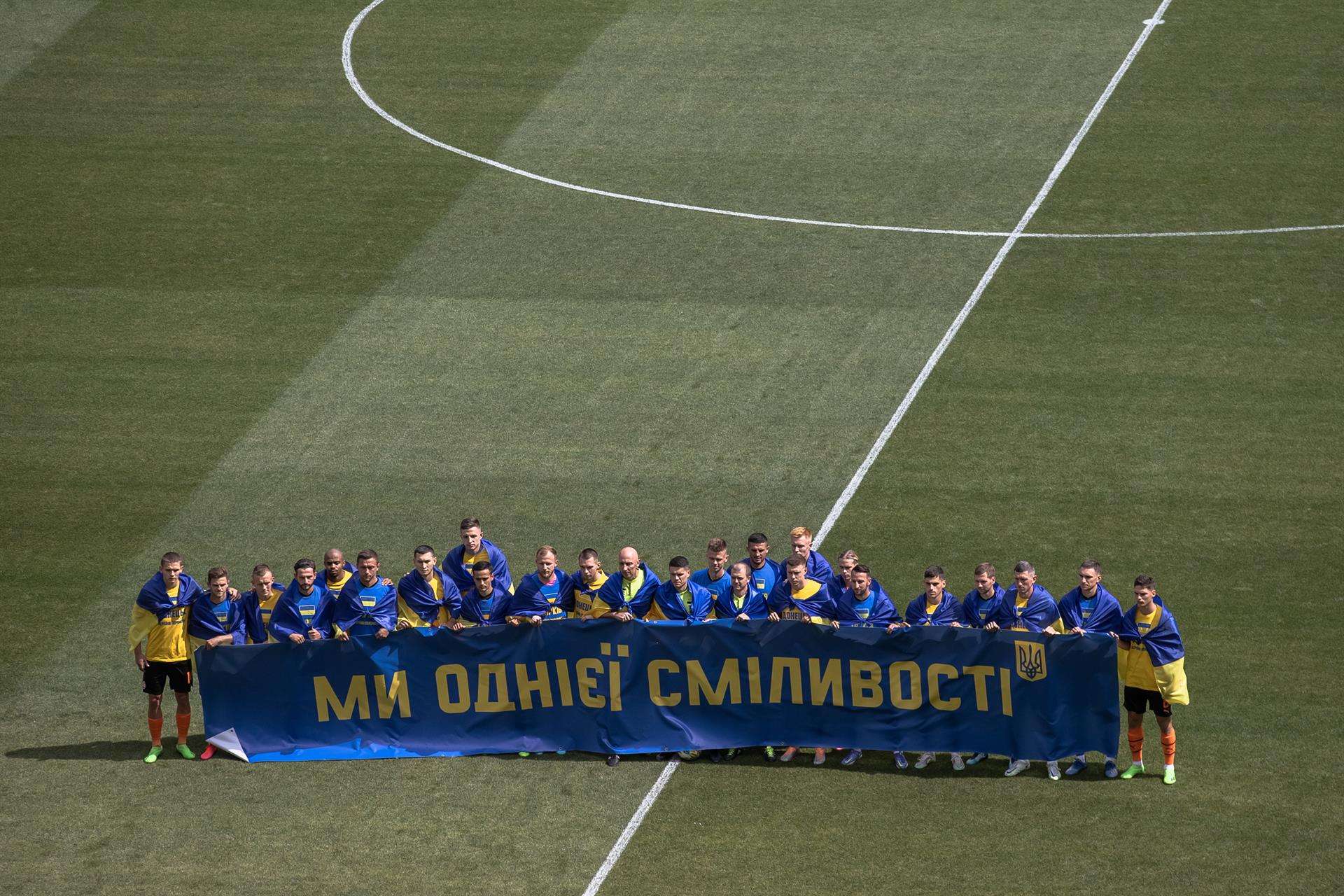 Jugadores del Shakhtar Donetsk y del Metalist 1925 Kharkiv con la bandera ucraniana antes del primer partido de la liga de Ucrania en Kiev. EFE/EPA/ROMAN PILIPEY