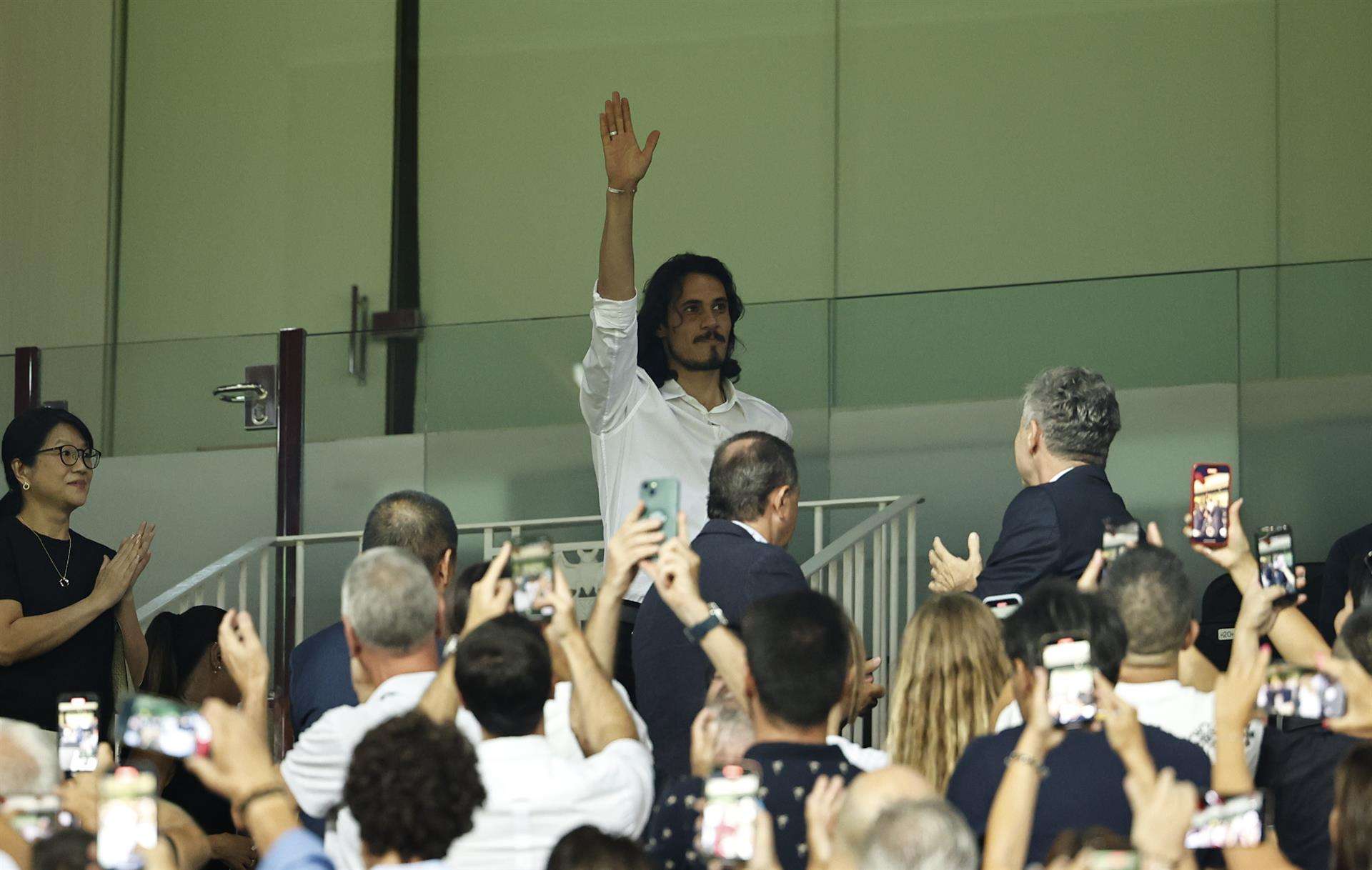 El delantero uruguayo Edinson Cavani, llegado a Valencia, saluda desde la grada antes de comenzar el partido de la tercera jornada de Liga en Primera División que Valencia CF y Atlético de Madrid disputan en el estadio de Mestalla. EFE/Biel Aliño