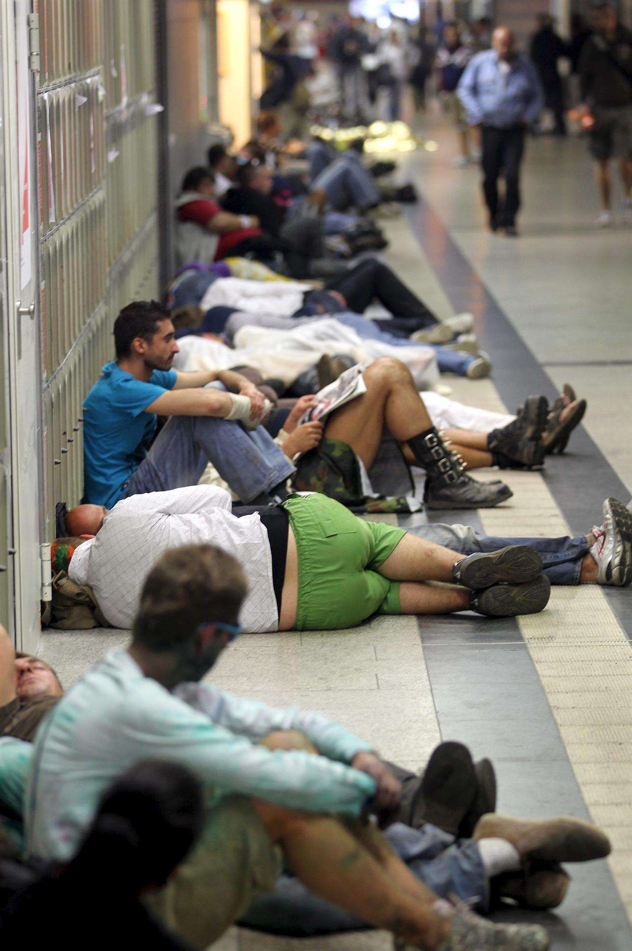 En la imagen de archivo, decenas de asistentes al "Loveparade" duermen en los pasillos de la estación principal de Duisburgo (Alemania). EFE/Roland Weihrauch
