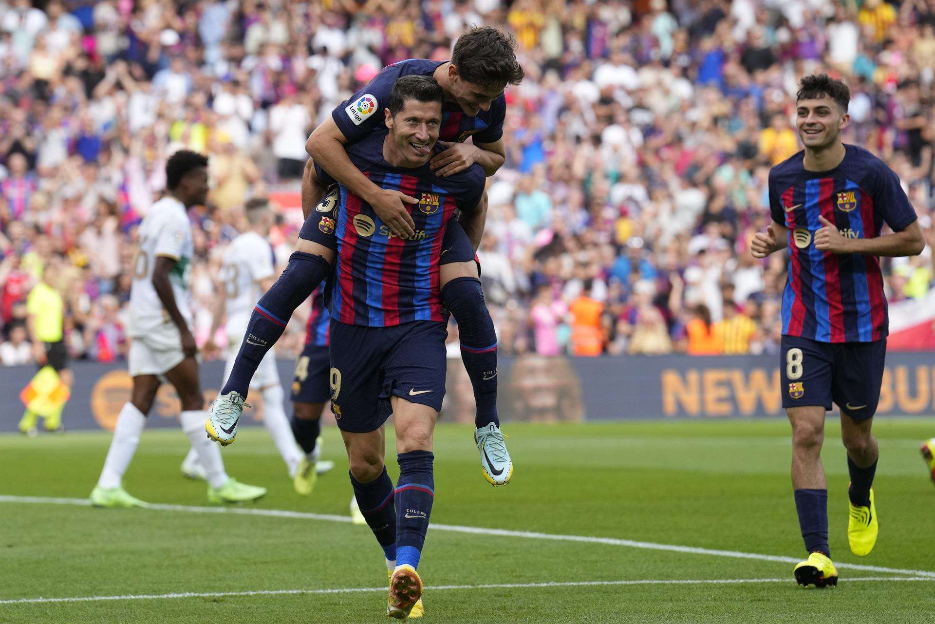 El delantero polaco Robert Lewandowski celebra su segundo gol contra el Elche, con los españoles Gavi y Pedri. EFE/Alejandro García