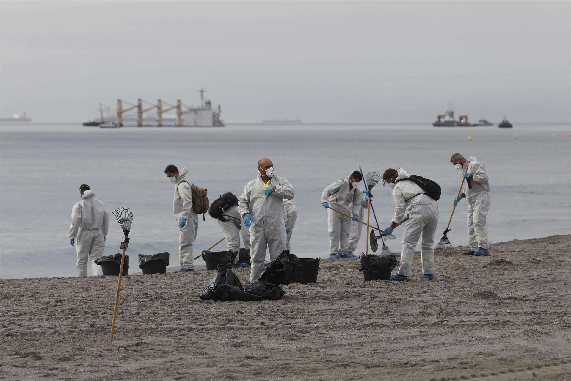En la imagen de archivo, operarios de limpieza, durante las tareas de limpieza de los restos de hidrocarburo procedentes del buque varado al Este de Gibraltar, el "OS 35" (al fondo en la imagen). EFE/A.Carrasco Ragel.