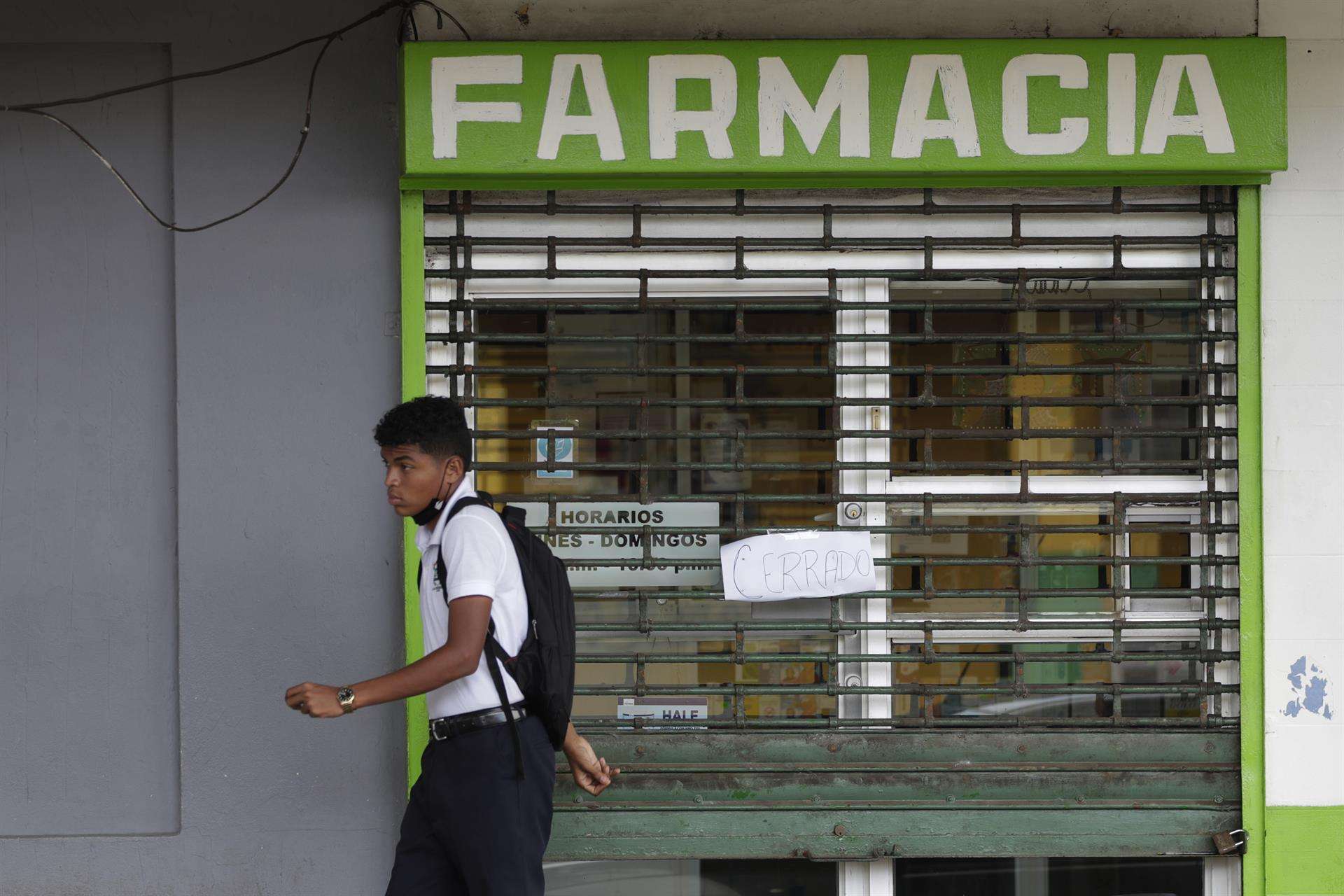 Una persona camina frente a una farmacia cerrada. EFE/Bienvenido Velasco