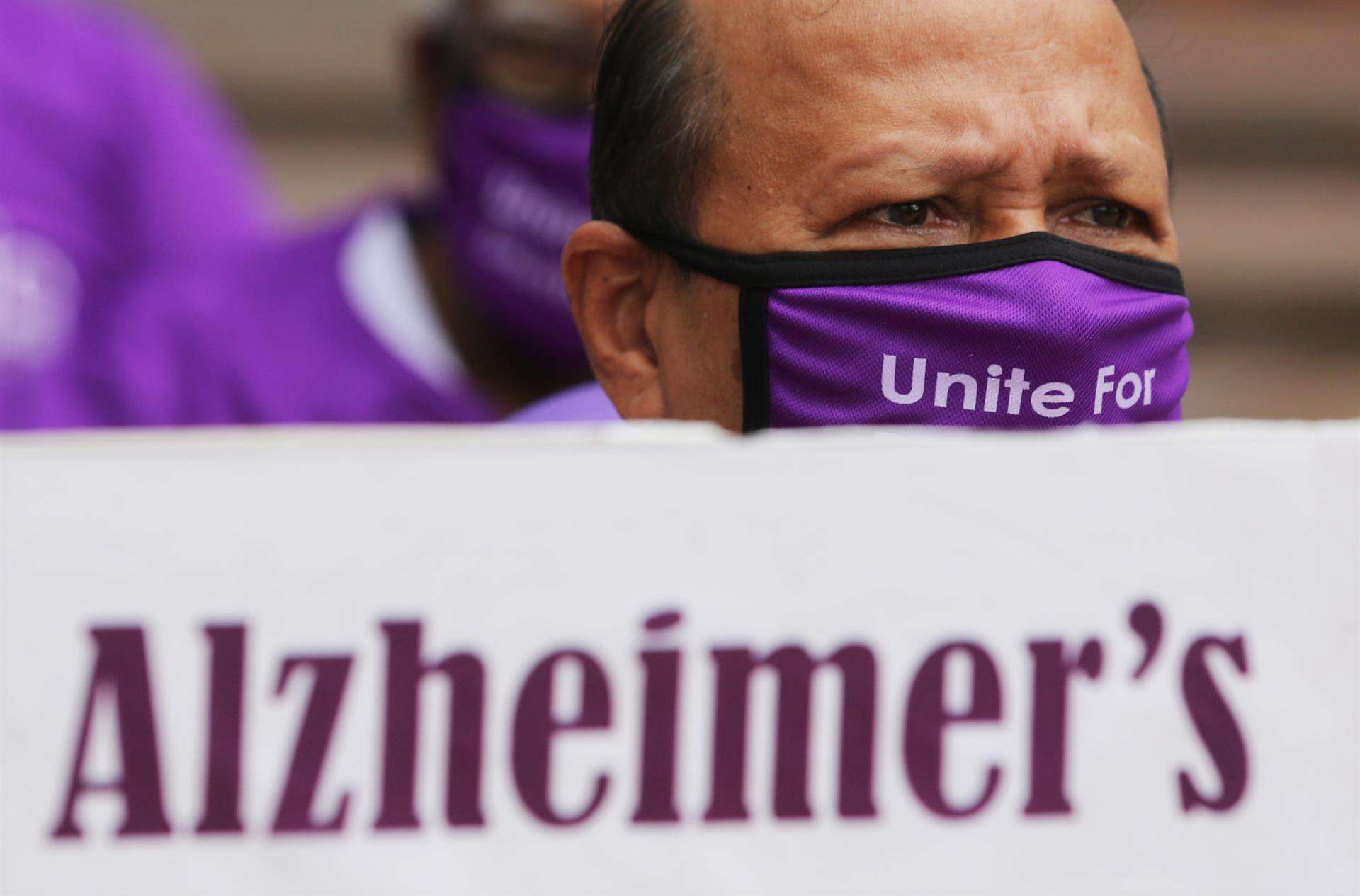 Una persona con una máscara púrpura sostiene una pancarta durante una reunión en el 'Día Mundial del Alzheimer'. EFE/EPA/JAGADEESH NV