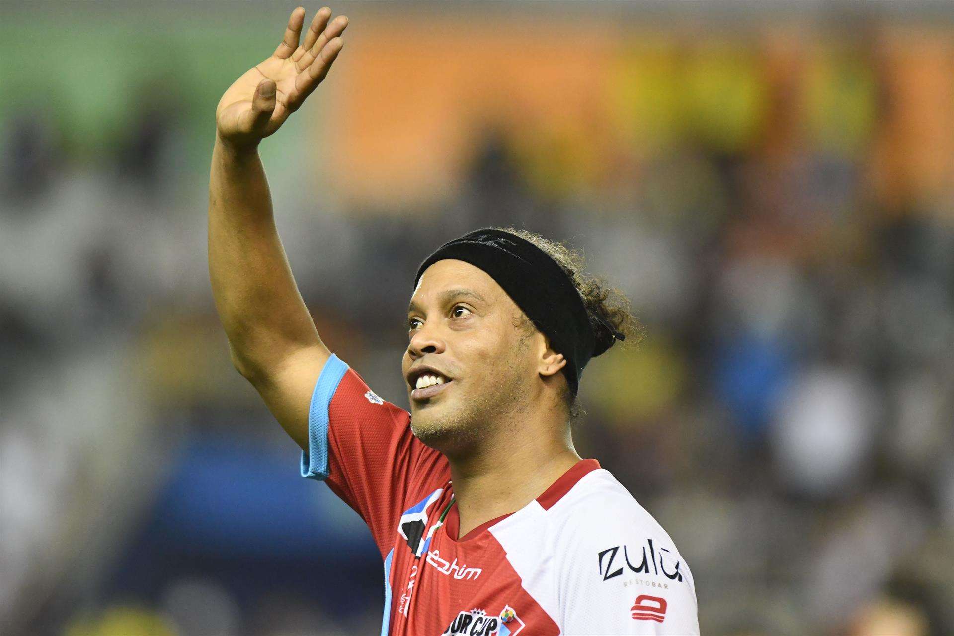 El exfutbolista brasileño Ronaldinho Gaúcho fue registrado este sábado, 24 de septiembre, al saludar, durante un partido de exhibición en el marco del torneo infantil Sur Cup Internacional, en el Estadio Jocay, en Manta (Ecuador). EFE/Ariel Ochoa