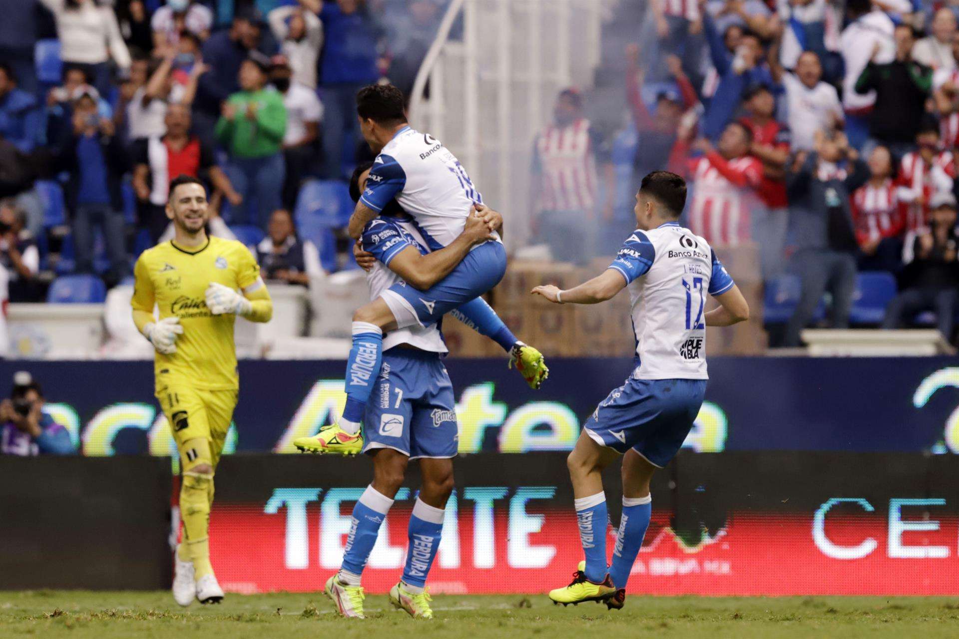 Los jugadores del Puebla festejan su triunfo contra el Guadalajara, hoy durante un partido de reclasificación del torneo Apertura 2022 de la Liga MX, en el estadio Cuauhtémoc, en Puebla (México). EFE/ Hilda Ríos