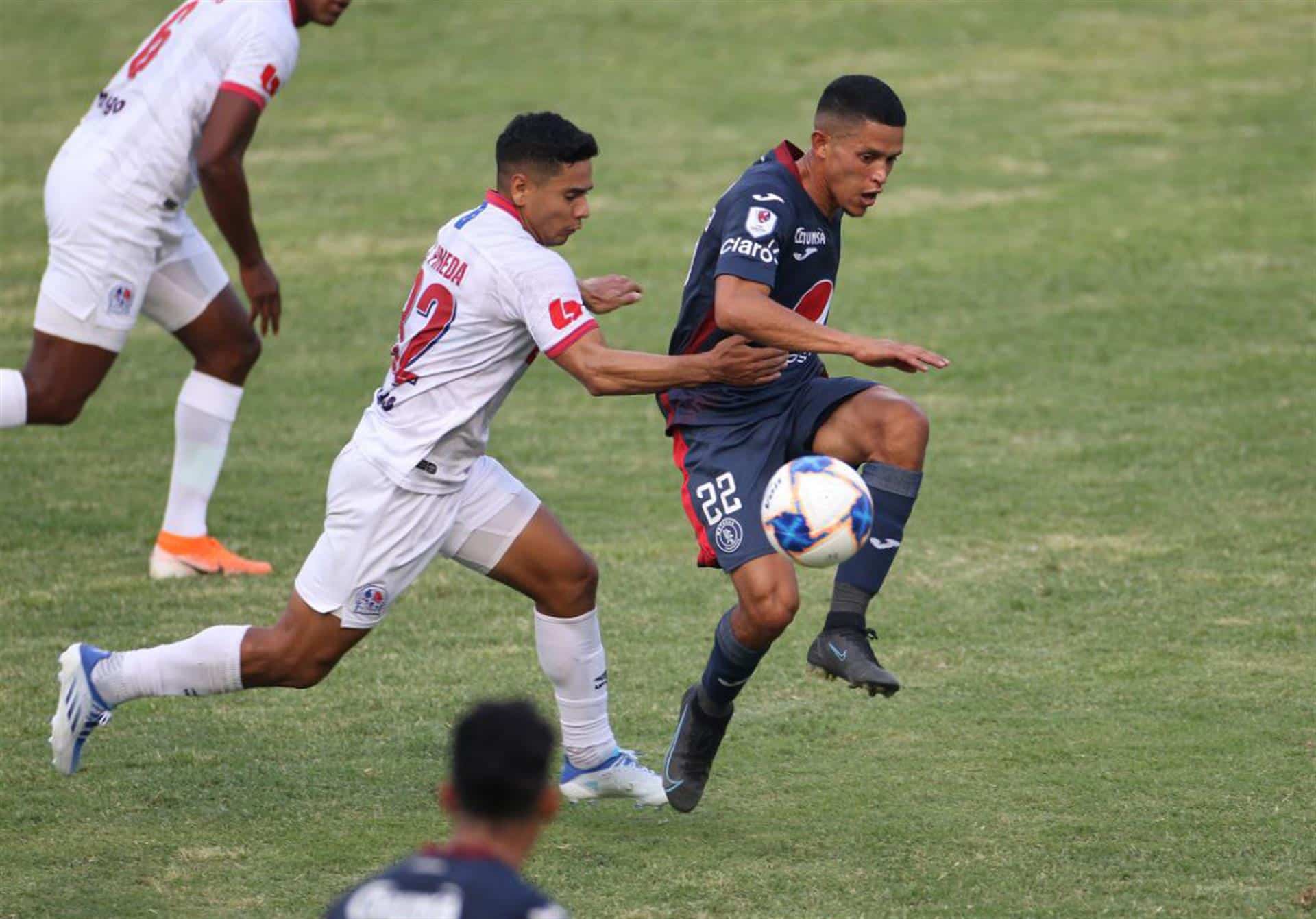 Fotografía de archivo, tomada el pasado 15 de mayo, en la que se registró la disputa de un balón durante un partido entre los clubes hondureños de fútbol Olimpia y Motagua, en el Estadio Nacional, en Tegucigalpa (Honduras). EFE/Humberto Espinoza
