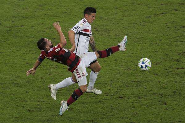 Everton Ribeiro (abajo), del Flamengo, fue registrado este domingo, 13 de agosto, al disputar un balón con James Rodríguez, del Sao Paulo, durante un partido de la fecha 19 del Campeonato Brasileño de fútbol, en el estadio Maracaná, en Río de Janeiro (Brasil). EFE/Antonio Lacerda