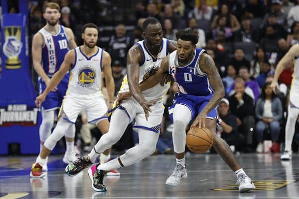 El jugador de Sacramento Kings Malik Monk (d) en una acción del encuentro en la NBA, disputa la pelota con el de los Golden State Warriors Draymond Green (c). EFE/EPA/JOHN G. MABANGLO