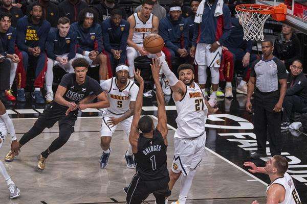 Nikola Jokić Jamal Murray (c-d), base canadiense de los Nuggets de Denver, fue registrado este viernes, 22 de diciembre, al bloquarle un disparo a Mikal Bridges (c), de los Nets de Brooklyn, durante un partido de la NBA, en el pabellón deportivo multiusos Barclays Center, en Brooklyn (Nueva York. EE.UU.). EFE/Ángel Colmenares