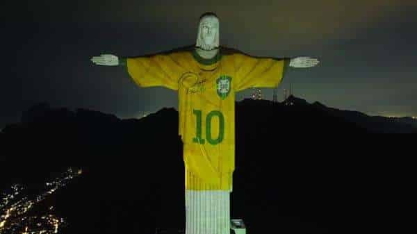Fotografía aérea tomada hoy que muestra al Cristo Redentor con la proyección de una camiseta de la selección brasileña de fútbol usada por Pelé, en Río de Janeiro (Brasil). La proyección forma parte de varios homenajes en todo Brasil por el primer aniversario de la muerte del "Rey del Fútbol". EFE/ANDRÉ COELHO