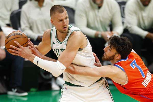 El letón Kristaps Porzingis (i), pívot de los Celtics de Boston, fue registrado este miércoles, 3 de abril, al disputar un balón con Chet Holmgren (d), pívot de los Thunder de Oklahoma City, durante un partido de la NBA, en el coliseo TD Garden, en Boston (Massachusetts, EE.UU.). EFE/CJ Gunther