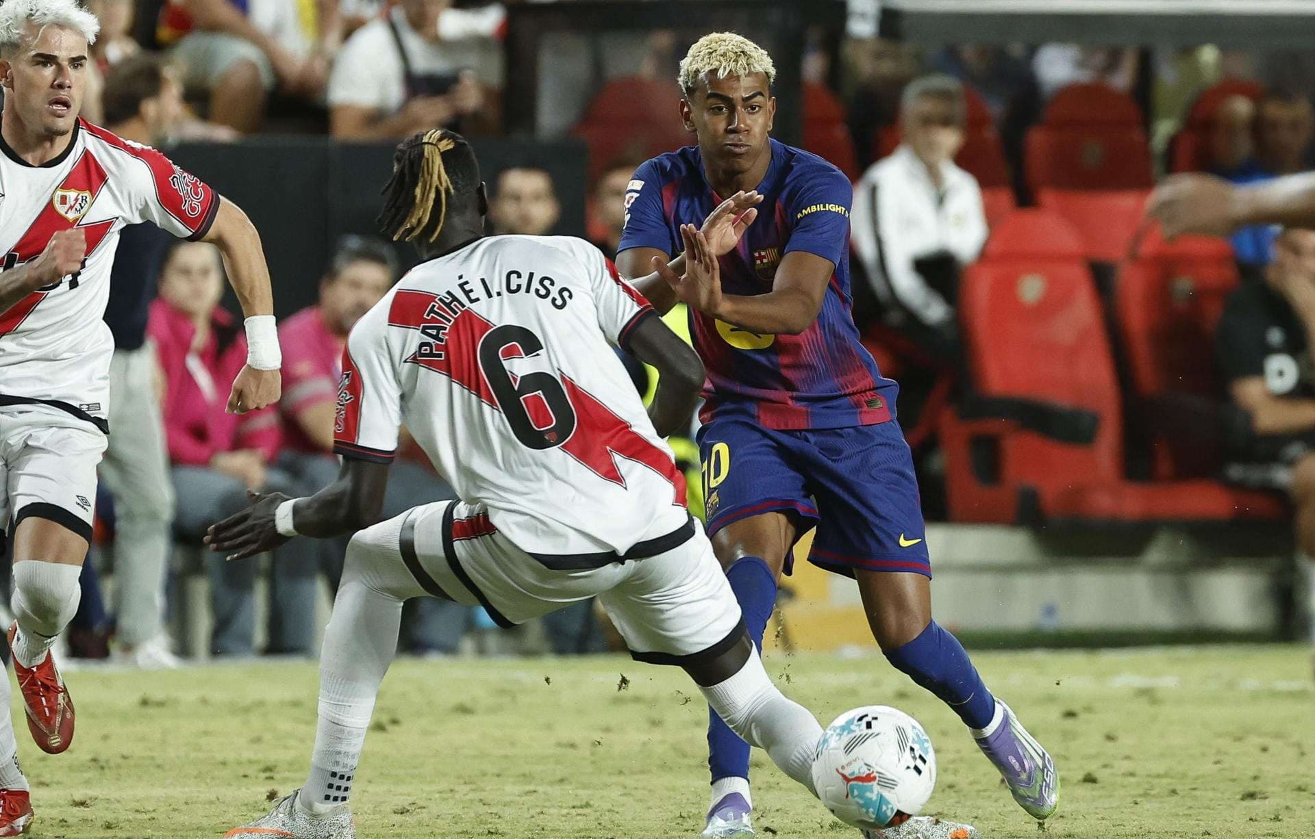 El centrocampista del Rayo Vallecano Pathé Ciss (i) lucha con Lamine Yamal, del FC Barcelona, durante el partido de la tercera jornada de LaLiga entre el Rayo Vallecano y el FC Barcelona, este domingo en el estadio de Vallecas. EFE/Chema Moya
