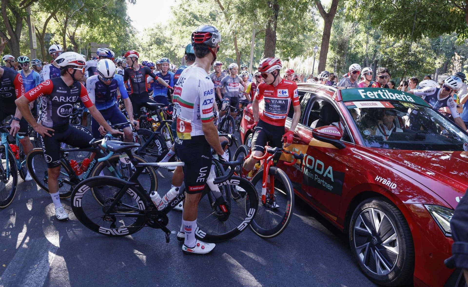 Ciclistas parados por las protestas en la última etapa de la Vuelta a España que se disputa este domingo entre las localidades madrileñas de Alalpardo y Madrid, con un recorrido 103,6 Km. EFE/Javier Lizón