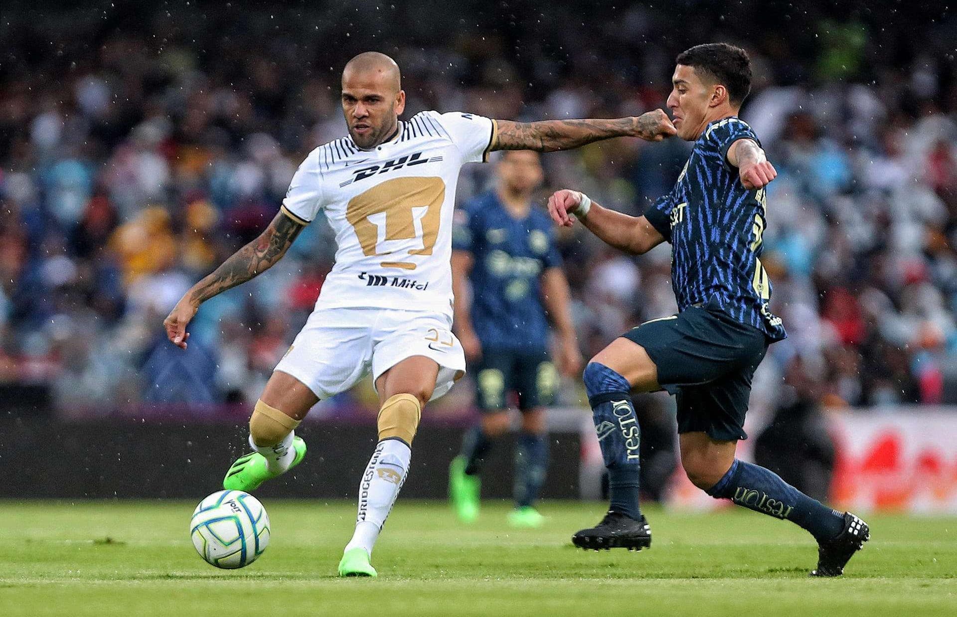 Dani Alves jugando con los Pumas disputa el balón con Alejandro Zendejas (d) del América. Imagen de archivo. EFE/Sáshenka Gutiérrez