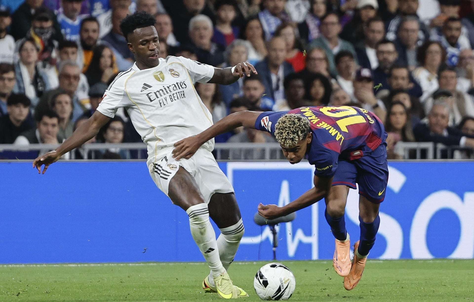 El delantero del Real Madrid Vinicius Jr, y el delantero del Barcelona Lamine Yamal, durante el partido de la décima jornada de LaLiga EA Sports, que Real Madrid y FC Barcelona disputan este domingo en el estadio Santiago Bernabéu. EFE/ Sergio Pérez