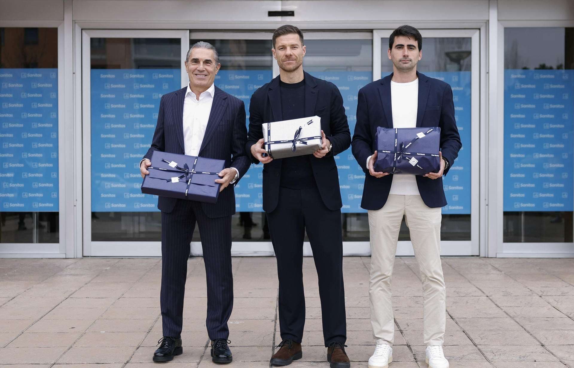 Los entrenadores de las distintas secciones del Real Madrid, Xabi Alonso (c), Sergio Scariolo (i) y Pau Quesada visitan este viernes el Hospital Universitario Sanitas La Moraleja para entregar los juguetes y regalos de Navidad a los niños. EFE/ Real Madrid