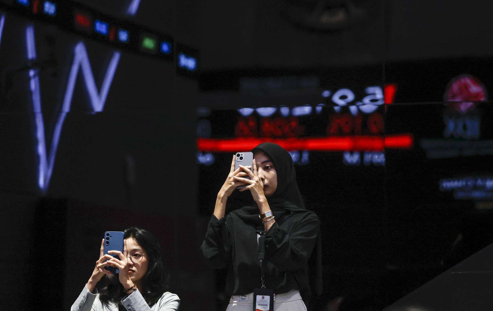 Fotografía de archivo, tomada el 08/04/2025, que muestra a dos mujeres usando teléfonos inteligentes en Indonesia. EFE/EPA/MAST IRHAM