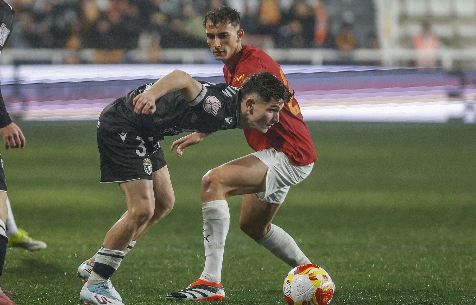 El centrocampista del Burgos Fermín García (i) lucha con Rubén Iranzo, del Valencia, durante el partido de octavos de final de Copa del Rey que Burgos CF y Valencia CF disputan este jueves en el estadio de El Plantío, en Burgos. EFE/Santi Otero